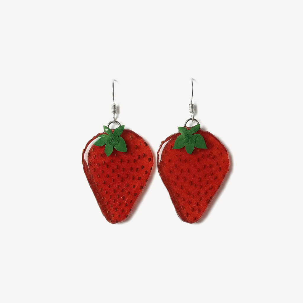 Strawberry-shaped earrings with green leaves on a white background